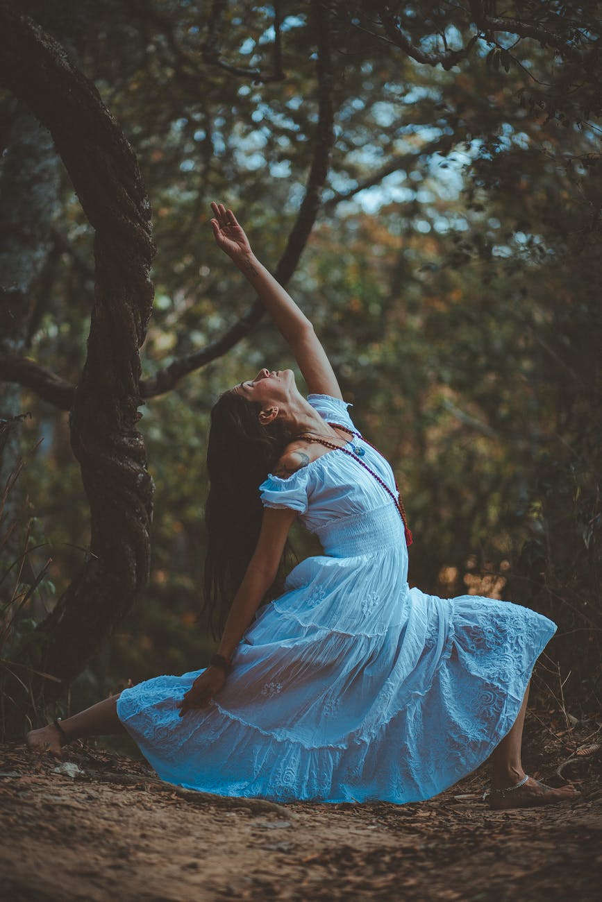 Woman performing a graceful yoga pose outdoors with natural light.